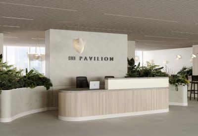 Modern reception area featuring a curved wooden desk and lush green plants