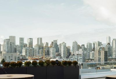 Wide view of a city skyline from a rooftop terrace with wooden decking.