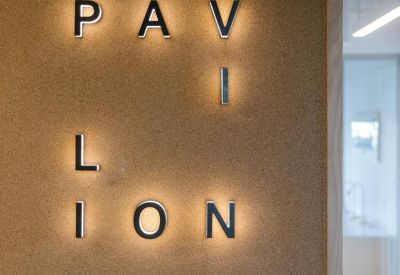 Backlit minimalist signage on a cork wall displaying the word Pavilion.