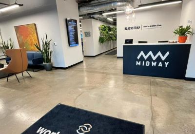 Lobby area with a branded Midway reception desk and a work-collective floor mat.