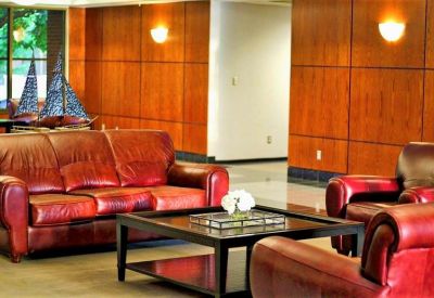 Lounge area with red leather sofas and warm wood paneling.