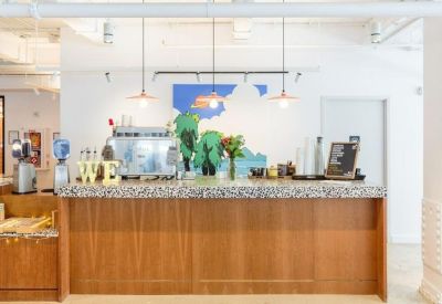 Cafe counter at 575 Lexington Avenue with wood paneling, stone countertop, and colorful mural.