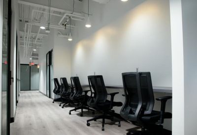 Sleek coworking hallway with integrated desk pods and modern lighting.
