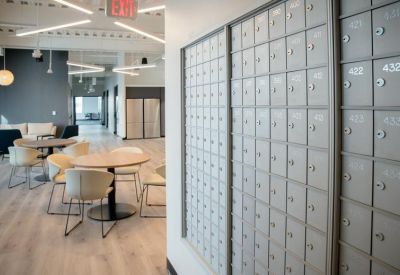 Modern hallway area featuring an array of grey mailboxes and a small dining table.