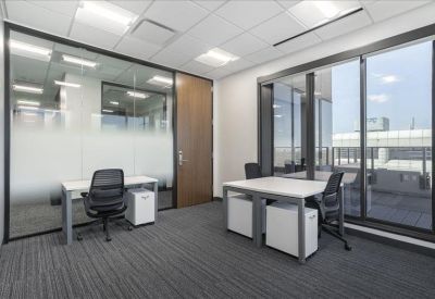 Modern private office with frosted glass partitions and window views.