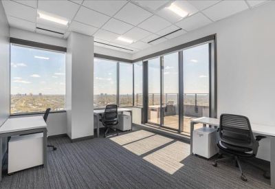 Spacious office suite featuring multiple workstations and floor-to-ceiling windows.