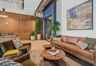 Modern reception lobby with wood-paneled walls and the Industrious logo.