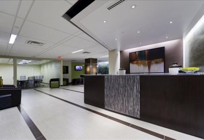 Professional reception area with a dark wood front desk and abstract wall art.