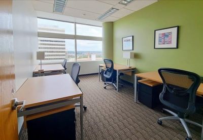 Modern breakroom with a large white table, red backsplash, and kitchen facilities.
