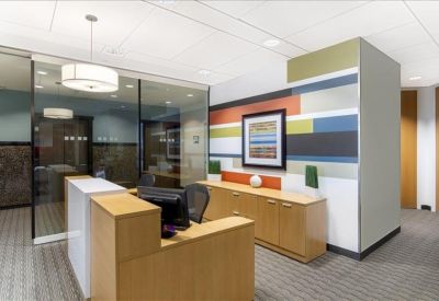 Bright reception area featuring a light wood desk and colorful striped feature wall.