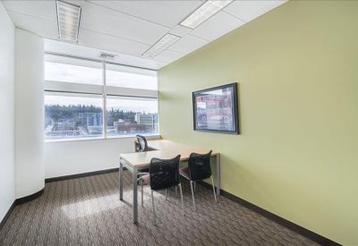 Private office with a corner desk and large windows overlooking the city.