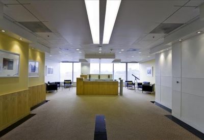 Bright, open reception lobby with a wooden front desk and comfortable seating areas.