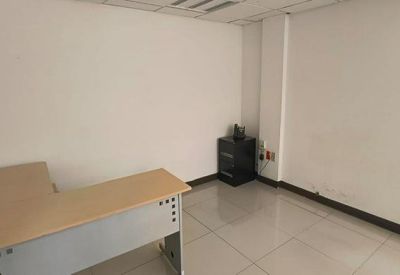 Spacious private office featuring a neutral-toned corner desk and tiled flooring.