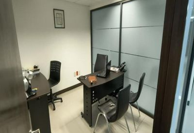 Small meeting room with frosted glass partitions and a dark wood desk.