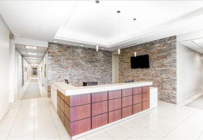 Modern reception area featuring a wood-paneled desk and a textured stone feature wall.