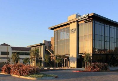 Exterior view of the modern glass and stone building at 6125, Paseo Del Norte, Suite 210.