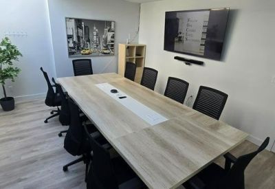 Meeting room with spacious table and wall-mounted TV.