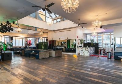 Open area with couches, chandeliers, and well-lit windows.