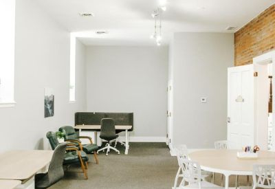 Open office area with minimalist workstations and a colorful striped rug.