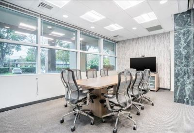 Modern conference room featuring a large wooden table and mesh chairs.