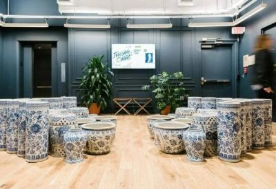 Lobby area featuring an artistic installation of blue and white ceramic vessels and potted plants.