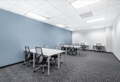 Internal office space with white desks, mesh chairs, and a pale blue feature wall.