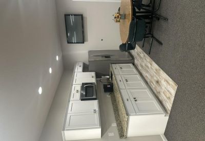 Functional kitchen area with granite-style countertops and white cabinets.