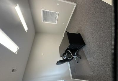 Private office with grey carpeting and overhead fluorescent lighting.
