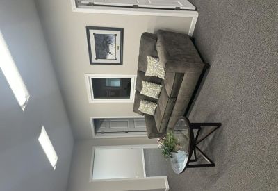 Cozy seating area with a sofa and glass table near an office entrance.