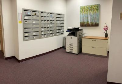 Office mailroom and utility area featuring silver mailboxes, a copier, and nature artwork.