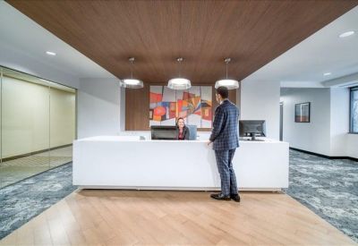 Bright reception desk area with wood accents and colorful abstract artwork.
