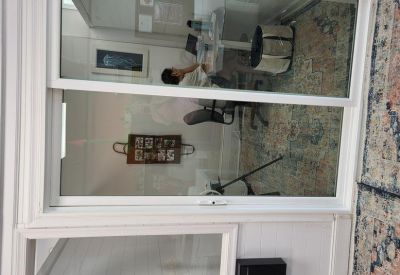 Glass-enclosed meeting room with a view into a shared workspace.