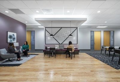 Collaborative breakout space with a central table and artistic wall mural.