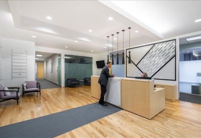 Reception desk with light wood paneling and decorative hanging lights.