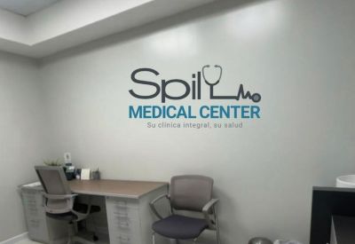 Compact office space with a desk, two chairs, and wall branding.