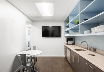 Communal kitchen area with breakfast bar and blue shelving.