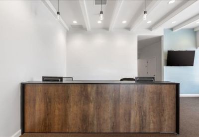 Professional reception area with a dark wood front desk and beamed ceiling.