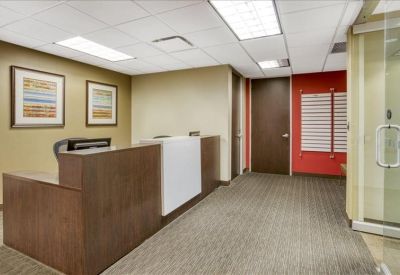 Professional reception area with a wooden front desk and red accent wall.