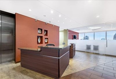 Professional reception area with a dark wood desk and warm terracotta feature wall.