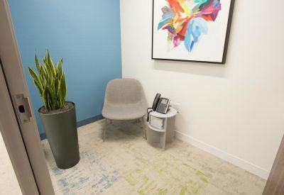 Modern kitchen and breakroom area with marble island and wood cabinetry.