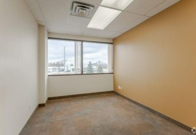 Private office with a beige accent wall and natural light.