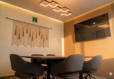Professional meeting room with a large wall-mounted TV and square geometric lighting.