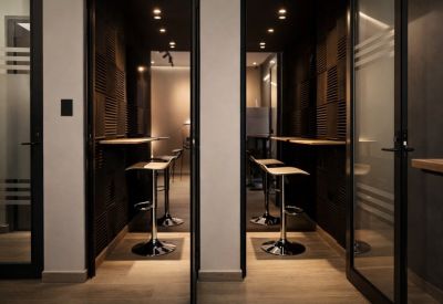 Private soundproof phone booths with stools and wooden counters.