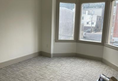 Private office featuring a large bay window and off-white walls.