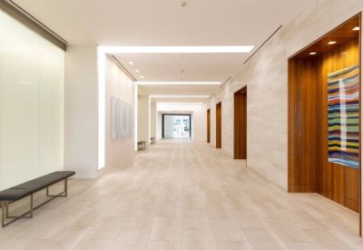 Bright, modern lobby corridor with light wood accents and colourful abstract wall art.