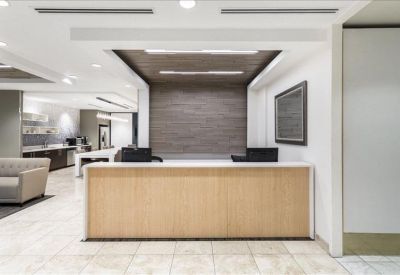 Modern reception desk with light wood paneling and a textured feature wall.