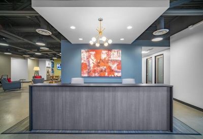 Reception area featuring a wood-paneled desk and abstract art against a blue wall.