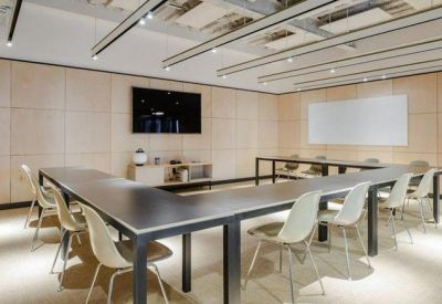 Professional meeting room with a U-shaped table and wall-mounted screen.