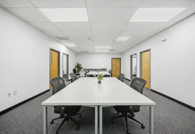 Large conference room featuring a long white table and multiple office doors.
