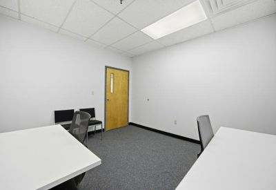 Private internal office with a light wood door and grey carpet.